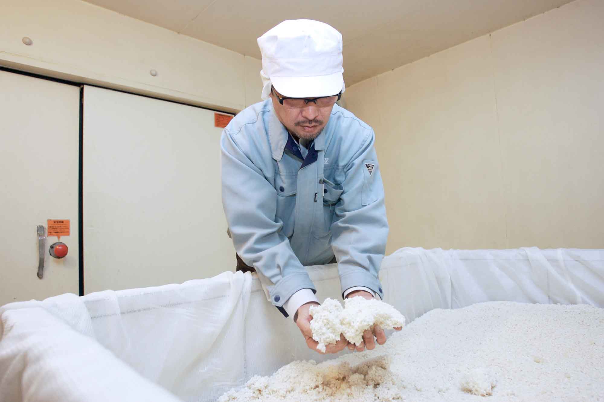 山形県アンテナショップおいしい山形　つくり手を訪ねて｜有限会社酢屋吉正：
                36℃の人肌くらいの温度になるように糀を手でほぐす作業。体に染み込んでいる熟練の感覚で糀を扱います。