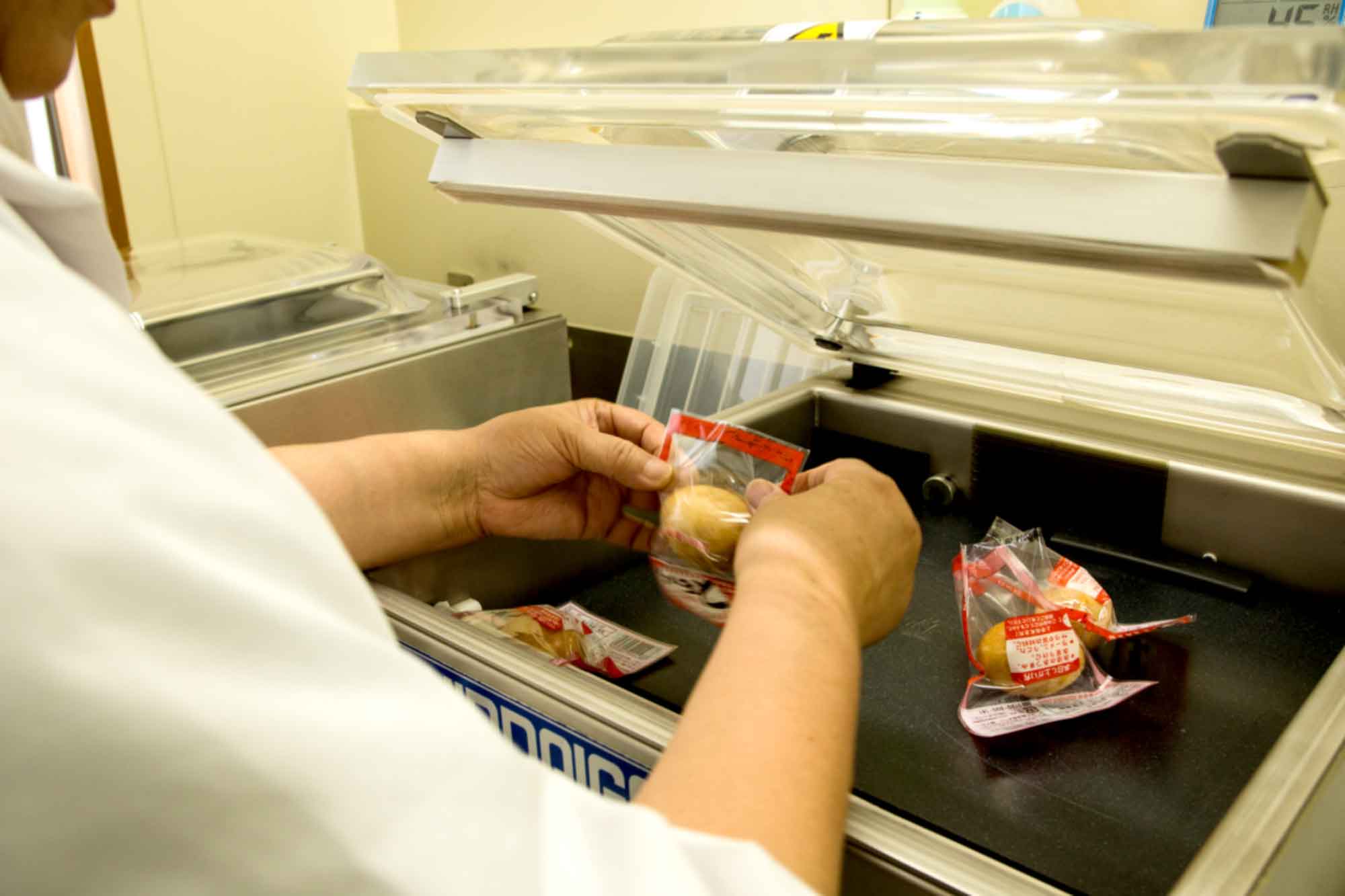 山形県アンテナショップおいしい山形　つくり手を訪ねて｜有限会社半澤鶏卵：
                一つ一つ丁寧に手作業で袋詰め。全工程を８人程の従業員でこなし、最盛期は夜遅くまで作業が続くとか。