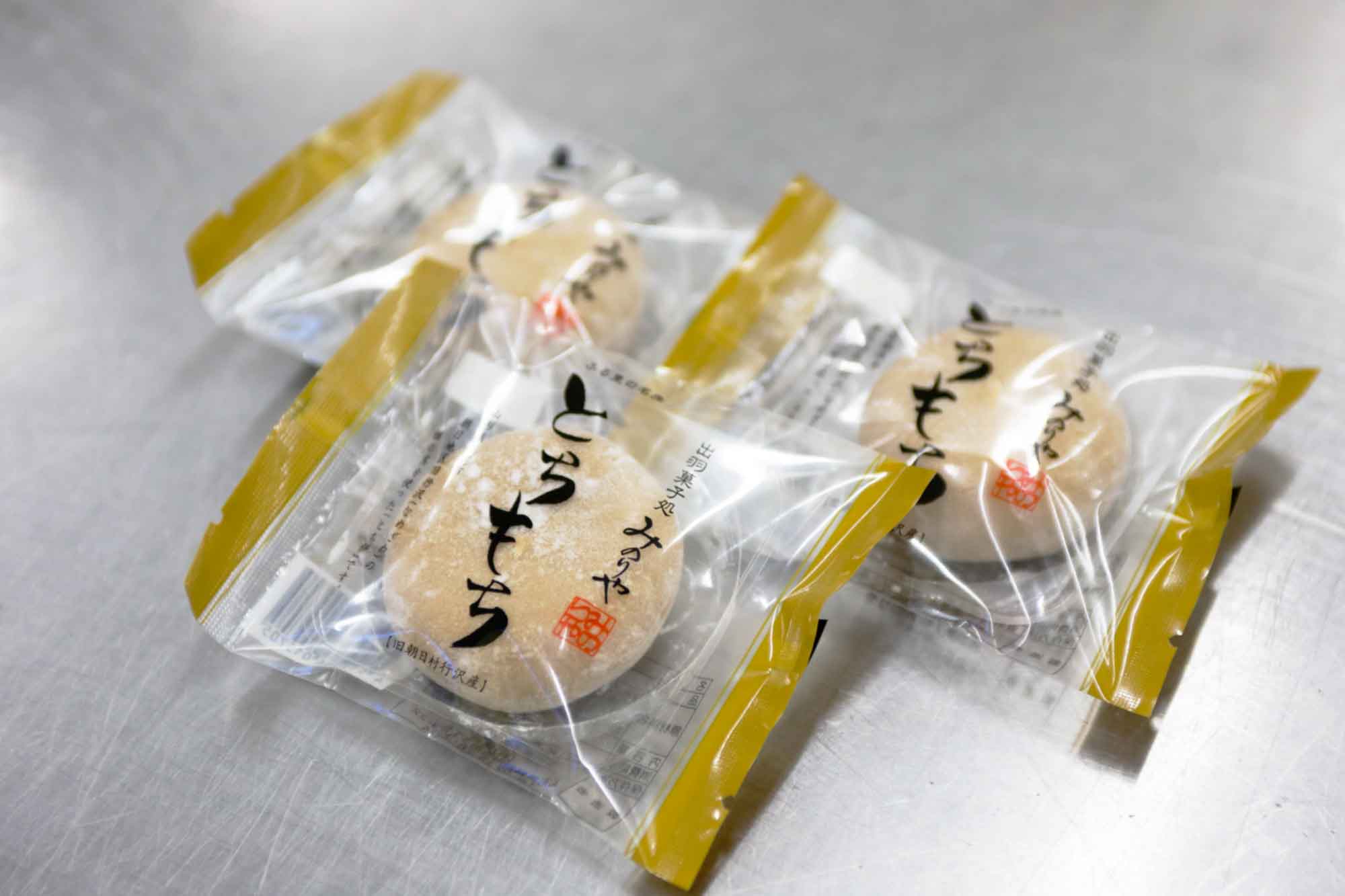 山形県アンテナショップおいしい山形　つくり手を訪ねて｜出羽菓子処みのりや（有限会社達商）：
                【完成】できたてのとちもち。パッケージには「行沢産」の文字も。